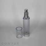 The Round Acrylic Airless Bottle, featuring a clear cylindrical design with a metallic silver pump dispenser and a removable transparent cap, is standing upright. The unbranded translucent body and cap are set against a plain white background. The word "COMPAX" is printed at the bottom left.