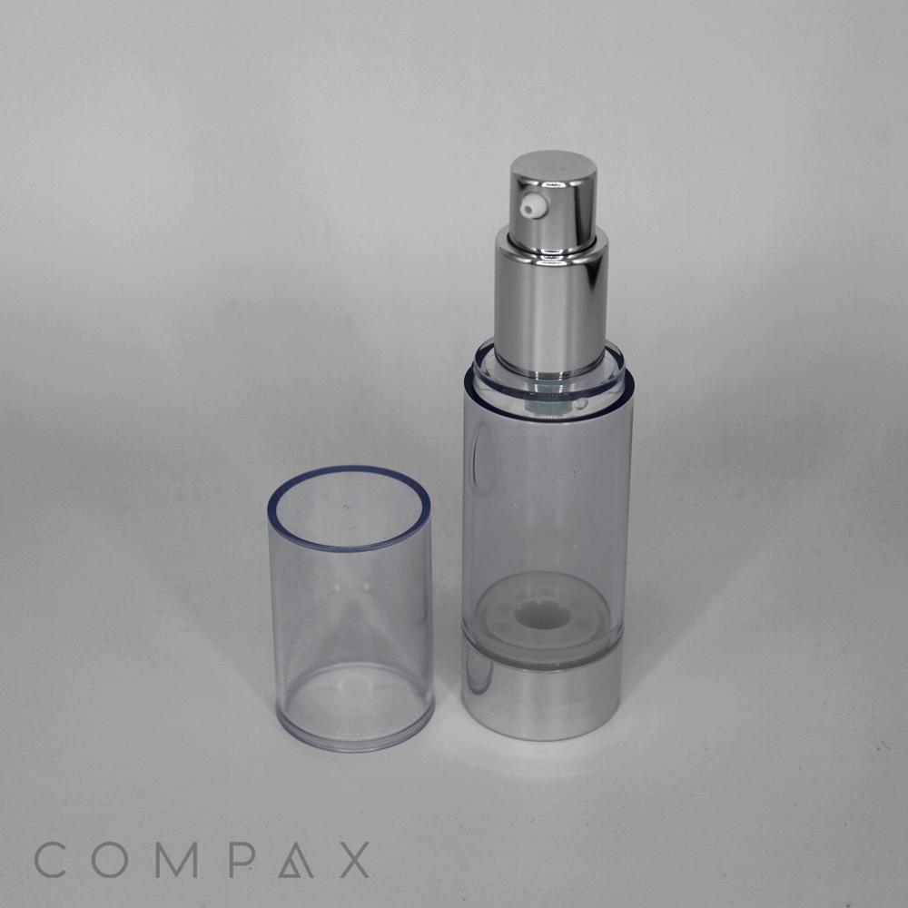 A Round Acrylic Airless Bottle with a silver nozzle and a transparent cap is placed beside it. The bottle's base and nozzle are metallic silver. The brand name "COMPAX" is visible in small letters at the bottom left corner of the image.