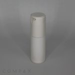 A stylish, fluted round airless bottle in pristine white, equipped with a pump dispenser, stands tall against a plain, light gray backdrop. The bottle's minimalist design boasts a smooth finish. The brand name "COMPAX" is subtly displayed at the bottom left corner of the image.