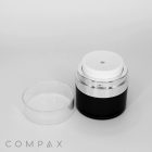 A black and white Round Airless Pump Jar with a clear lid removed, revealing the dispenser top. The brand name "COMPAX" is visible at the bottom left corner of the image. The container has a sleek, minimalist design with silver accents.