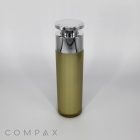 A slender, cylindrical "Round Airless Bottle" with a gradient design transitioning from olive green at the base to a frosted clear at the top. It features a shiny silver cap and is labeled "COMPAX" at the bottom left. The background is plain white.