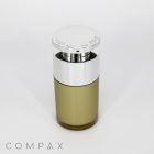 A cylindrical Round Airless Bottle of perfume with a metallic silver cap on top. The bottle is partially transparent, revealing a yellowish-green liquid inside. "COMPAX" is written in light grey at the bottom left corner of the image.