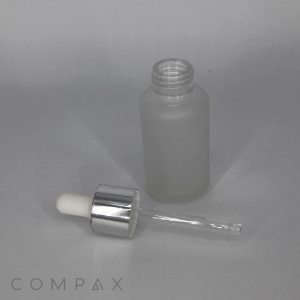 A 30mL glass cylinder round bottle is paired with a detached glass pipette and metallic cap resting beside it on a smooth surface. The brand name "COMPAX" is subtly printed in light grey text in the bottom left corner of the image.