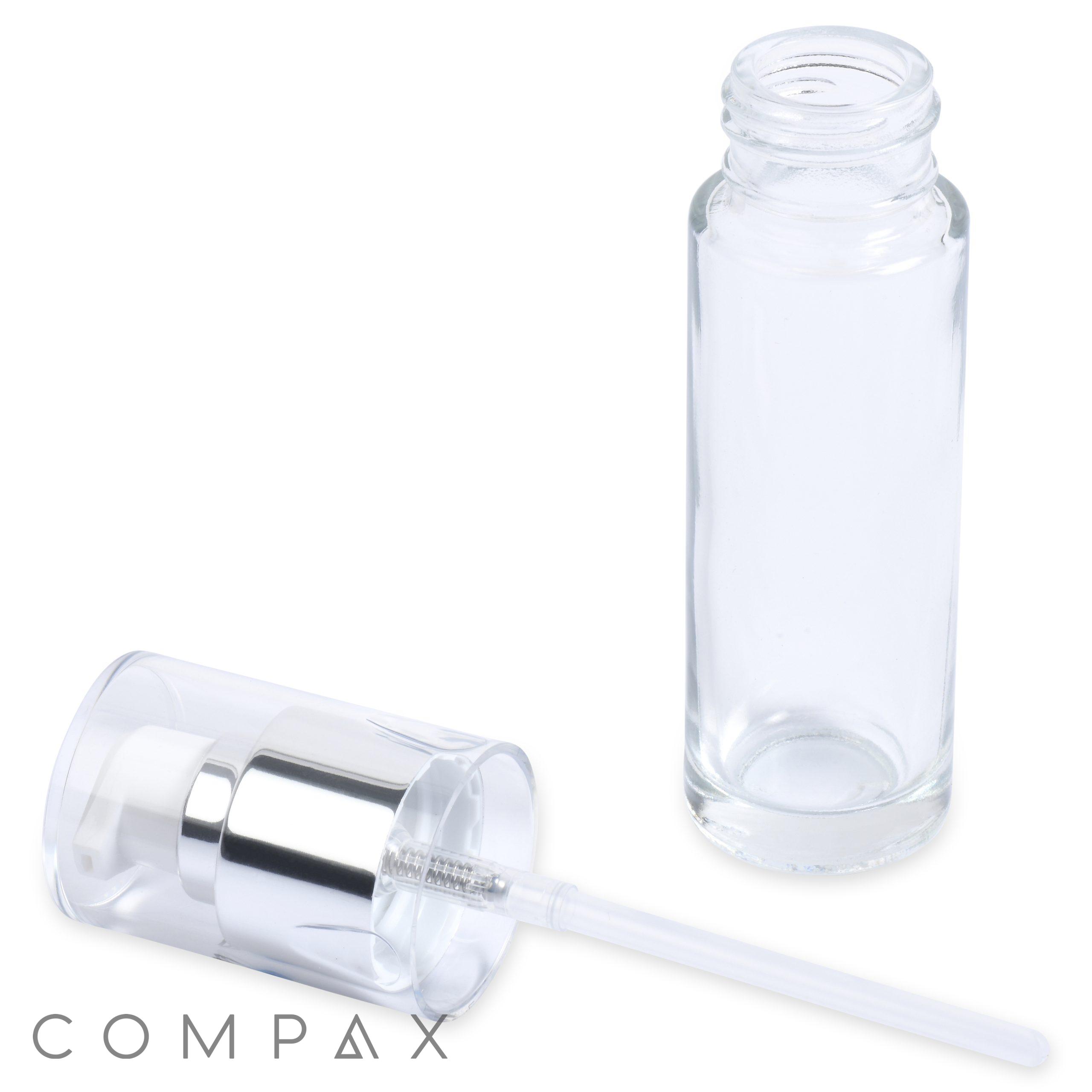 A clear, empty 30mL Glass Cylinder Round Bottle stands upright next to a detached, matching clear plastic screw cap with a silver band. A small dip tube extends from the inside of the cap. The brand name "COMPAX" is visible in the lower-left corner.