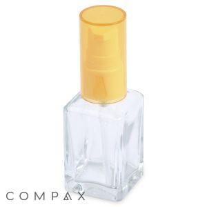 A 30mL Square Glass Dropper Bottle, small and clear with a yellow plastic spray nozzle and cap, sits empty. The word "COMPAX" is partially visible in the bottom left corner of the image, showcasing its minimalist and functional design.