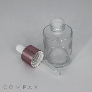 A 30mL Glass Round Bottle with an open top is positioned next to a dropper cap. The dropper has a white rubber bulb and a metallic purple collar. The word "COMPAX" is displayed in the bottom left corner on a white background.
