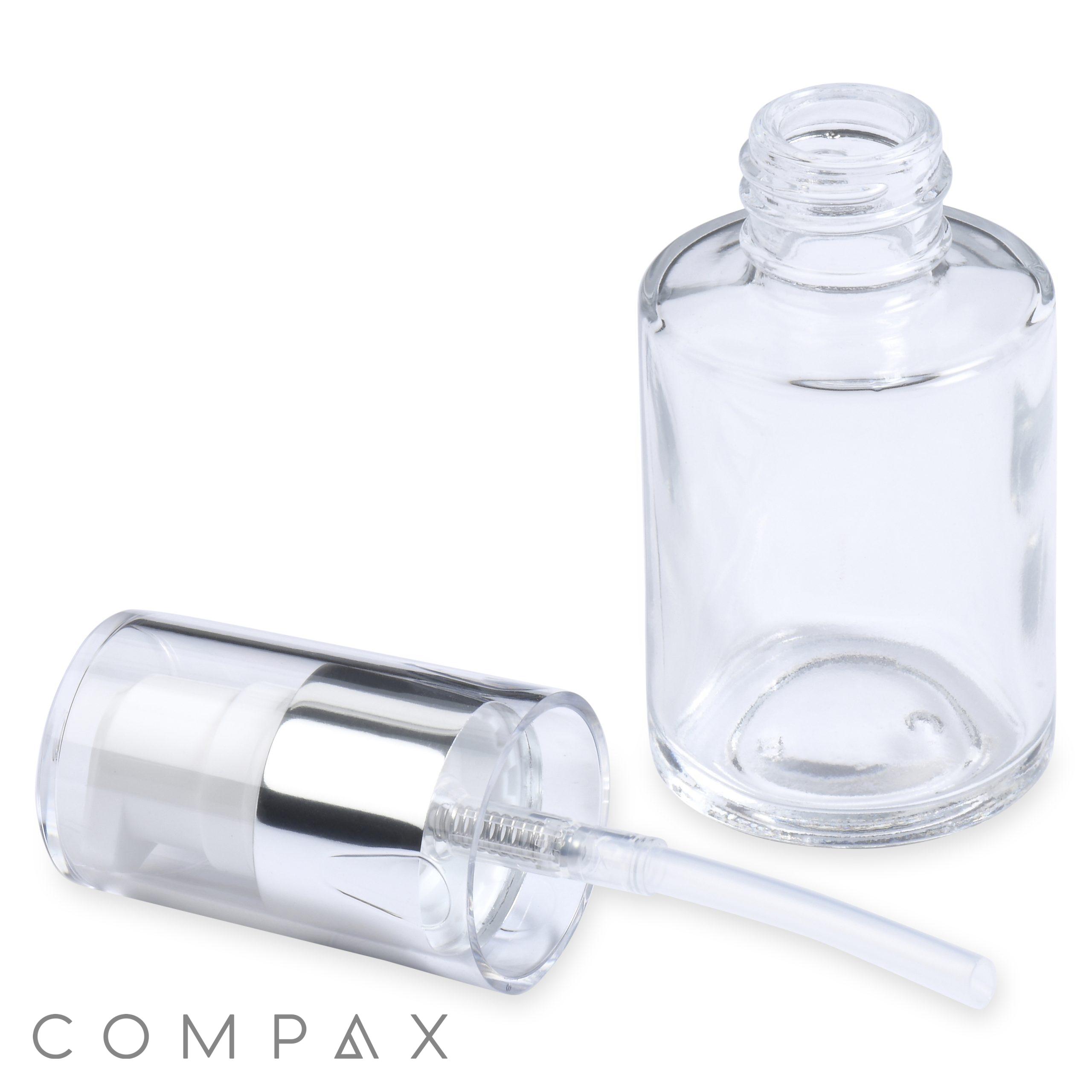 A 30mL Glass Cylinder Round Bottle lies open with the cap and pump laying next to it. The cap is silver and clear with a visible pump tube. The bottle is cylindrical and transparent. The word "COMPAX" appears at the bottom left corner of the image.