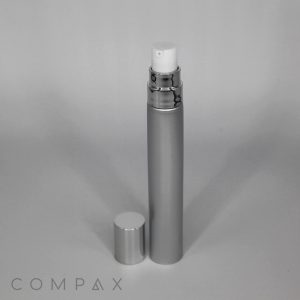 A 19mm Airless Pump Tube with a detached cap placed next to it on a neutral gray background. The tube has a sleek, cylindrical design and a metallic finish. The word "COMPAX" is visible in the bottom left corner of the image.