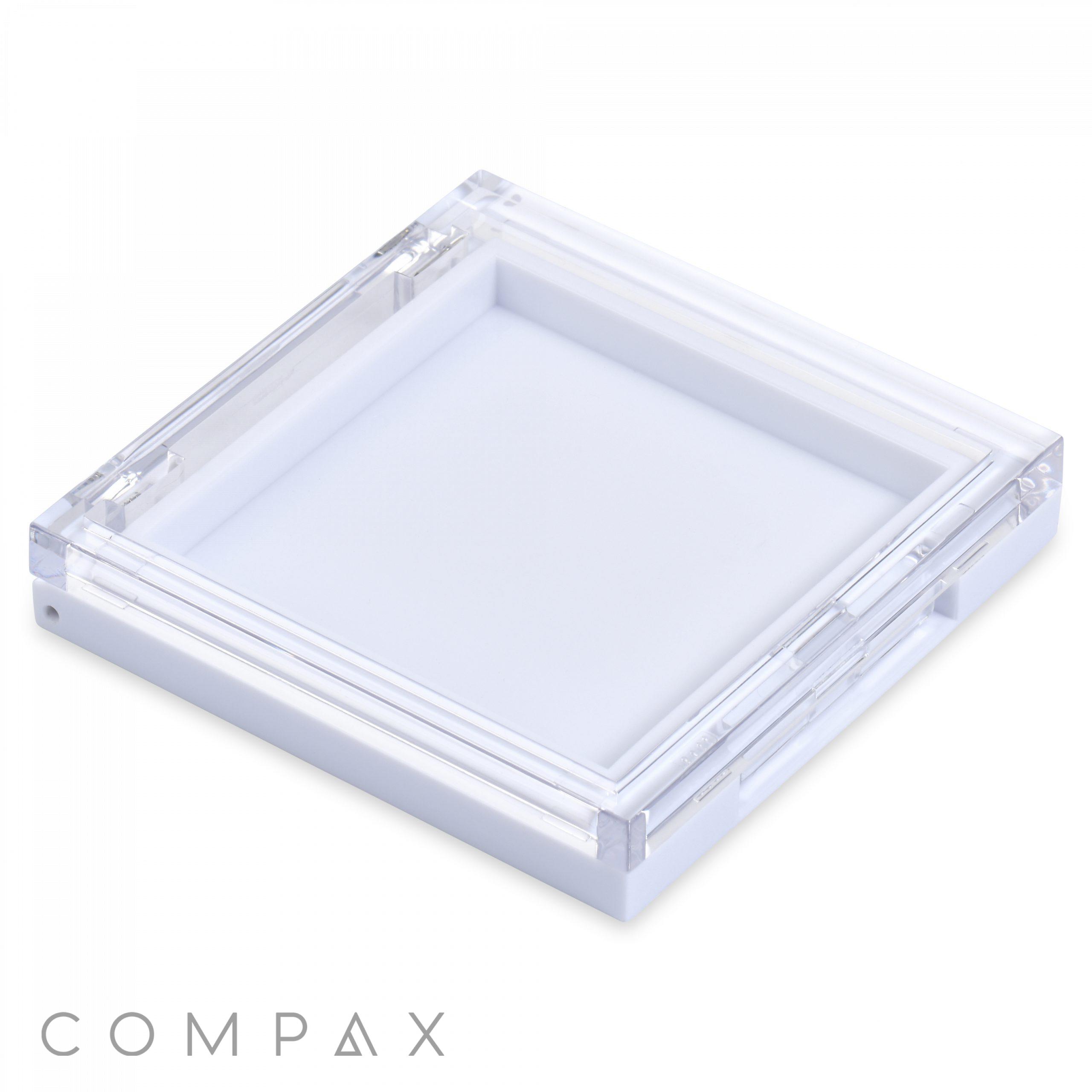 A clear, square, acrylic container with a hinged lid and a white base, photographed on a white background. This Square Single Pan Compact is designed for holding small items, and the word "COMPAX" appears in gray text near the bottom left corner.