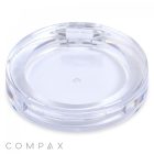 A clear, round, shallow plastic container with a smooth surface and a latch for sealing. The brand name "COMPAX" is visible at the bottom left corner. This Round Single Pan Eyeshadow Compact appears to be empty and is designed for holding small items or cosmetics.