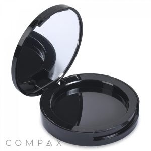 The Round Single Pan Blush Compact is a round, black case with an open lid and a mirror inside. The compact features a glossy finish and the brand name "COMPAX" is clearly visible in the bottom left corner of the image.
