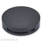 A sleek, black Round Single Pan Blush Compact with a glossy finish sits against a white background. The bottom edge has a slight opening, likely the hinge for opening the case. The brand name "COMPAX" is written in a minimalist font in the bottom left corner.
