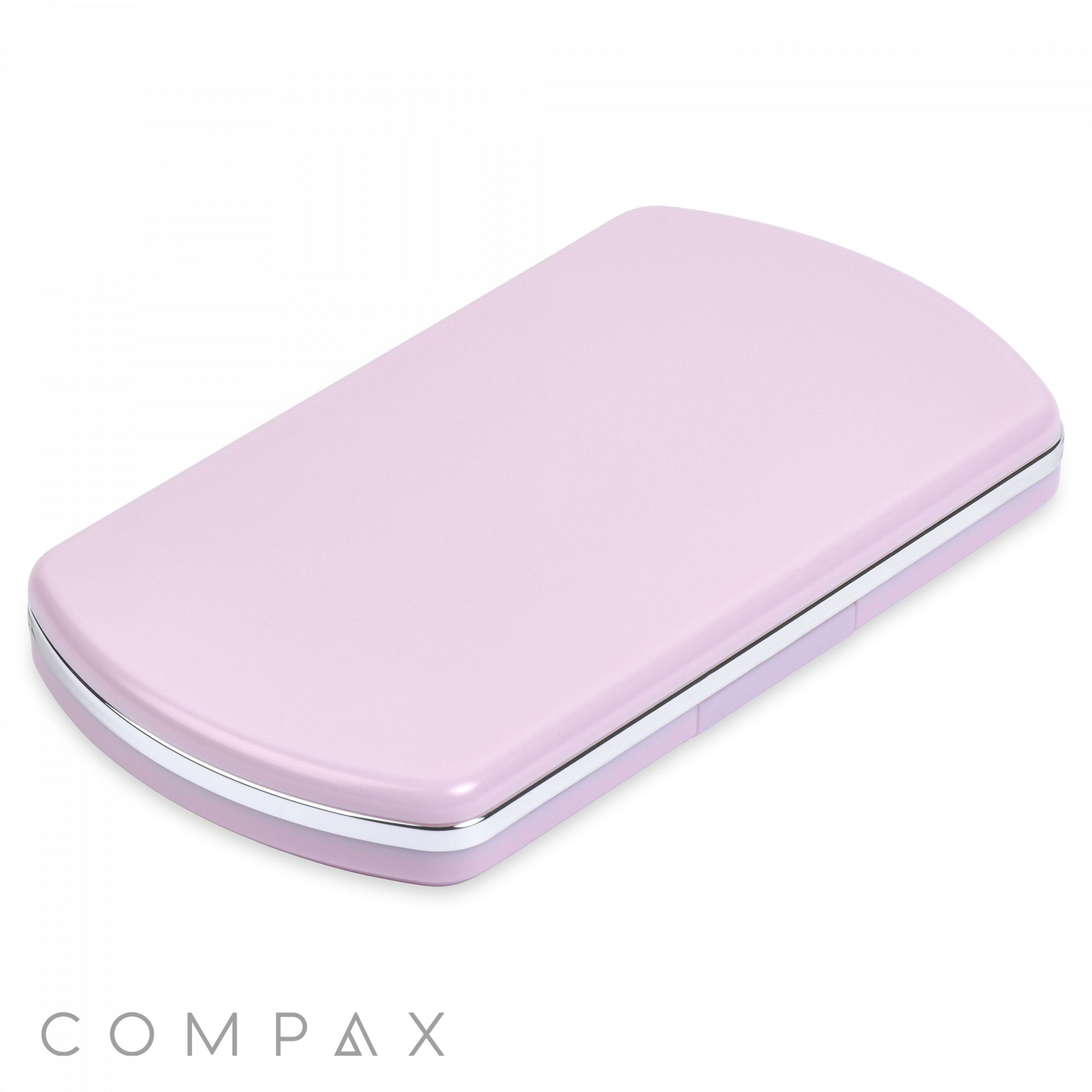 A sleek, rectangular Bullet 2 Round Pan Powder Compact in light pink, featuring rounded corners and a thin silver trim along the edge. The brand name "COMPAQ" is displayed in small letters at the bottom-left corner of the image. The mirror is closed.
