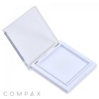 A Square Single Pan Compact, featuring a white square plastic design and a hinged transparent lid, is open to display its empty shallow compartment. The brand name "COMPAX" is printed in gray near the bottom left corner of the image.