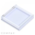 The Square Single Pan Compact features a transparent square design with a white base and a clear lid. The lid has angular corners and is slightly raised above the base. "COMPAX" is written in gray capital letters on the bottom-left corner, with a white background.