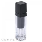 A sleek, transparent square lip gloss bottle with a black cap. The bottle features a minimalist design and the word "COMPAX" is displayed in gray text at the bottom left corner.