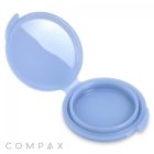 A blue, round, empty "Round Single Pan Compact" with a hinged cover is shown open. The compact has a mirrored lid, and the brand name "COMPAX" is visible in the lower left corner.