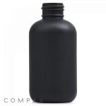 A 4oz Boston Round Bottle crafted from matte black plastic, featuring a cylindrical shape and a wide, threaded neck. The bottle is plain without any labels or markings, with the branding "Compax" visible in the bottom left corner of the image.