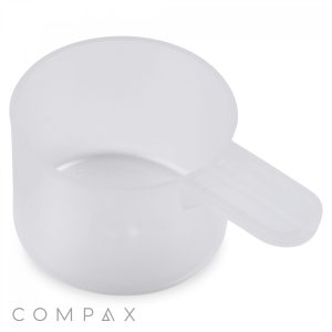 A 90cc scoop made of transparent plastic with a short handle, specifically designed for measuring dry or powdered ingredients. The background is white, and the scoop has no visible measurement unit markings. The word "COMPAX" is printed in the lower left corner.