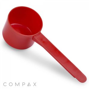 A red 53cc plastic measuring scoop with a long handle is shown against a white background. The word "COMPAX" is printed at the bottom left corner of the image.