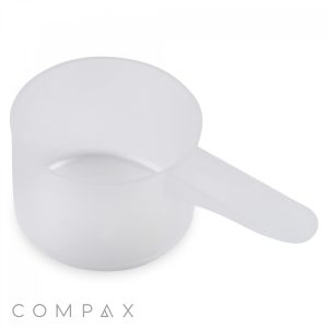 A 47cc Scoop made of translucent plastic with a handle, viewed from a slight angle above. The background is white, and the word "COMPAX" is visible in small, gray text at the bottom left corner.