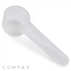 The image shows a 5cc Scoop, featuring a cylindrical cup at the end of an elongated handle and made from transparent plastic. It is likely used to measure powder or granular substances. The brand name "COMPAX" is displayed at the bottom left corner of the image.