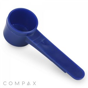 A 6.5cc blue plastic measuring scoop with a long handle is displayed against a white background, featuring the "COMPAX" branding in the bottom-left corner.