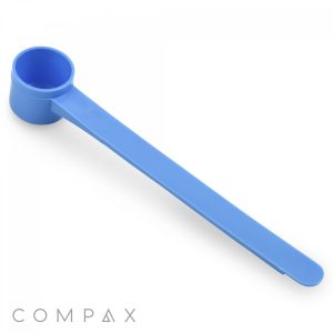 A 6.5cc blue plastic measuring scoop with a long handle, designed for portioning out powders or granules, is displayed against a white background. The brand name "COMPAX" is visible in the bottom left corner.