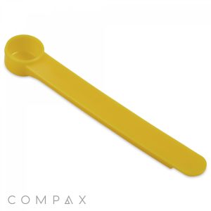 A yellow, plastic 1.25cc Scoop from Compax. The scoop features a circular measuring cup at one end and a long, flat handle that tapers slightly towards the opposite end. The word "COMPAX" is displayed in light gray text near the bottom left corner of the image.