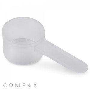 A translucent, plastic 20cc Scoop with a long handle. The scoop is empty and placed against a plain white background. The word "COMPAX" is visible in the bottom left corner.