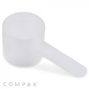 A 26.5cc white plastic measuring scoop with a long handle, ideal for powders such as protein or supplements, is placed on a white surface with the brand name "COMPAX" displayed in the bottom left corner.