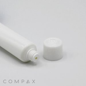 A close-up image of a white, plastic squeeze tube positioned on its side with its cap removed and lying next to it. The tube has a threaded neck and the cap appears to have a flat top. The background is plain and white. The text "13mm Screw Top" can be seen at the bottom.