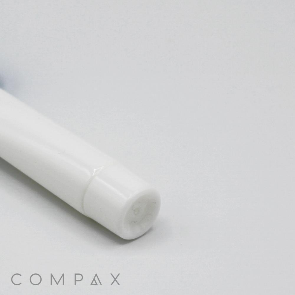 Close-up image of the bottom portion of a white cylindrical object, possibly a 13mm Screw Top, against a plain white background. The word "COMPAX" is visible in gray text at the bottom left corner.