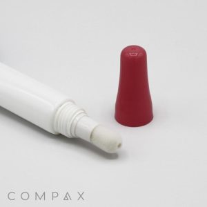 A white tube with a red cap lies on its side against a white background. The cap is removed, revealing the 16mm Sponge Applicator tip. The word "COMPAX" is visible in the bottom left corner of the image.
