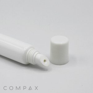 A small, white, cylindrical tube with its cap removed, lying on a white surface. The tube features a pointed applicator tip, ideal for dispensing cream or gel products. The brand name "COMPAX" is displayed in light grey text at the bottom left corner. This product is identified as the 13mm Lip Applicator.