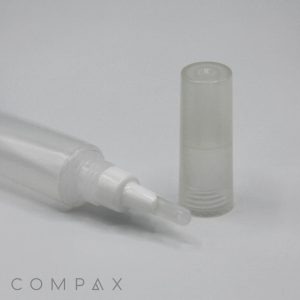 A 19mm Silicone Brush Applicator with a transparent cylindrical tube and a white wand applicator is lying on its side next to a clear cylindrical cap. The background is plain white, and there is "COMPAX" text in the bottom-left corner.
