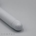 A close-up view of a 19mm Lip Applicator, showcasing its white cylindrical body with a rounded, ribbed cap, resting on a light grey surface. The word "COMPAX" is partially visible in the bottom left corner.
