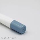 A 19mm Needle Nose pen with a light blue cap lies flat on a clean, light gray surface. The pen is branded with "COMPAX" in sleek, minimalist text at the bottom left corner of the image.