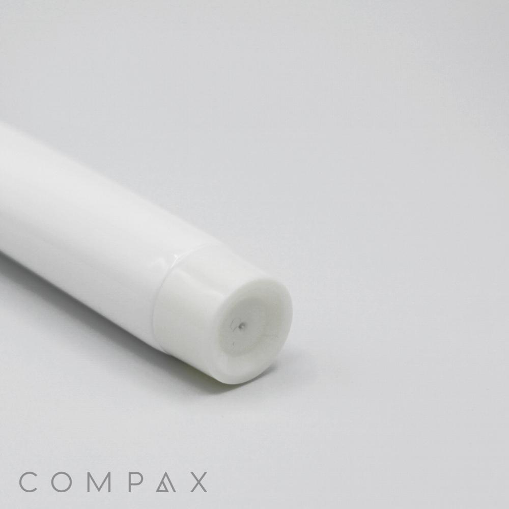 A close-up view of the 22mm Screw Top at the end of a cylindrical, white plastic tube against a light gray background. The word "COMPAX" is visible in light gray text at the bottom left corner of the image.