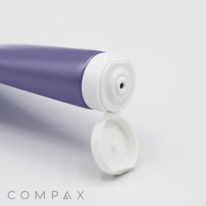 A close-up of a purple squeeze tube with a white, flip-top cap that is open, revealing the tube's dispensing nozzle. The tube is positioned horizontally against a white background, and the product name "25mm Flip Top" is displayed in the bottom left corner.