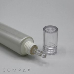 A close-up of a grey, cylindrical bottle with a white cap removed and placed next to it. The bottle's opening is fitted with a 25mm Dropper Tip precision applicator. The word "COMPAX" is printed in the bottom left corner.