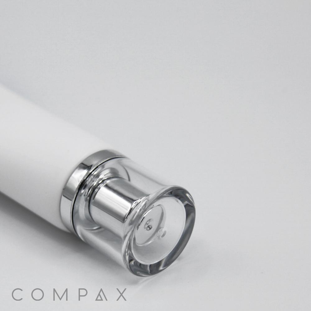 A close-up image of a sleek, cylindrical white and silver bottle labeled "25mm Screw Top" lies on a plain white surface. The transparent bottle cap reveals a small amount of the contents inside. The text "COMPAX" is visible in the bottom left corner.