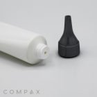 A close-up image of an open 30mm Needle Nose Twist tube with its gray cap removed, placed on a flat light gray surface. The gray cap features a precision spout for controlled dispensing. The brand name "COMPAX" is visible in the bottom left corner of the image.