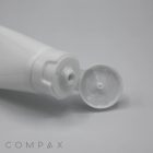 A close-up image of a white plastic squeeze tube with an open 30mm Flip Top cap. The nozzle is visible, and a small amount of the product may be seen, indicating it is ready for use. The word "COMPAX" is written in the bottom left corner.