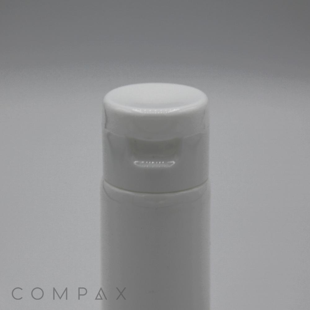 A close-up image of a white plastic bottle with a 30mm flip-top cap. The lid features a slight lip for easy opening. The background is plain and light grey, with the subtle text "COMPA X" visible at the bottom left corner.