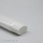 A close-up of a white plastic tube labeled "30mm Flat Screw Top" with a white cap lying on a light gray surface. The text "COMPAX" is visible in the bottom-left corner.
