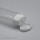 A 30mm Oval Flip Top clear plastic bottle with a white flip-top cap is shown lying on its side. The cap is open, revealing the nozzle for dispensing the bottle's contents. The brand name "COMPAX" is printed in the bottom left corner of the image.