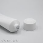 A white tube of the 35mm Screw Top product lying on its side with the cap removed and placed next to it on a plain, light background. The word "COMPAX" is written at the bottom left corner of the image.