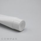 A close-up view of the cap of a white, cylindrical 35mm Screw Top tube, likely used for packaging creams, lotions, or gels. The tube is placed against a plain, light-colored background. The word "COMPAX" is visible in the bottom left corner of the image.