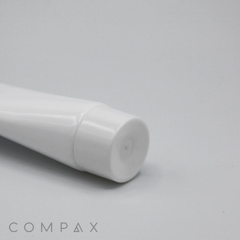 A close-up view of the cap of a white, cylindrical 35mm Screw Top tube, likely used for packaging creams, lotions, or gels. The tube is placed against a plain, light-colored background. The word "COMPAX" is visible in the bottom left corner of the image.